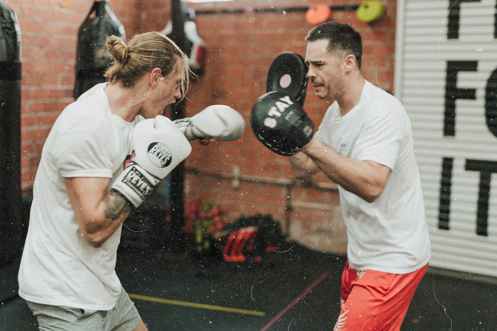 Fighter drilling pad work with a coach late in fight camp