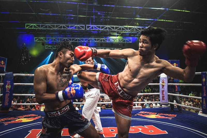 Muay Thai fighter throwing a roundhouse kick in the ring